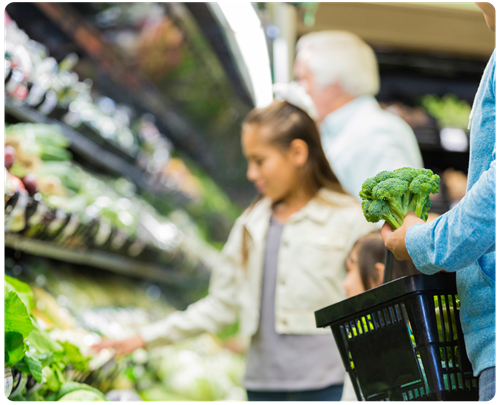 Hispanic family grocery shopping in produce aisle