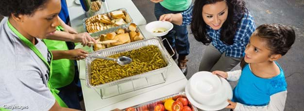 Mom and daughter being served a meal at food bank kitchen