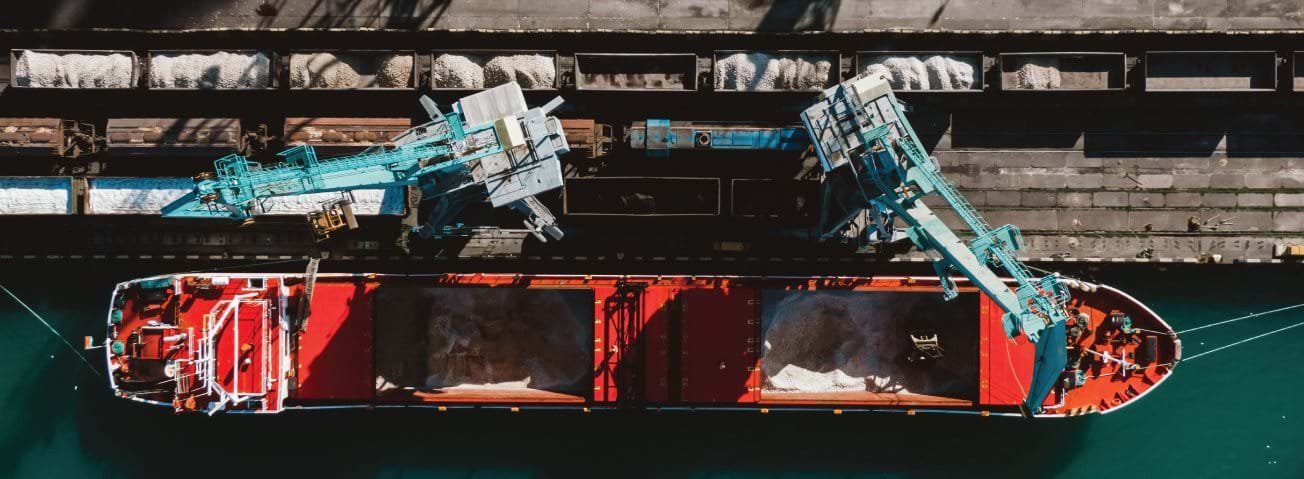 Ship loading fertilizer at a port.