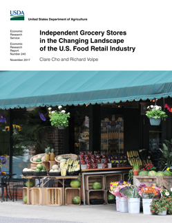 The front entrance of a quaint neighborhood market showing flowers and fresh produce for sale